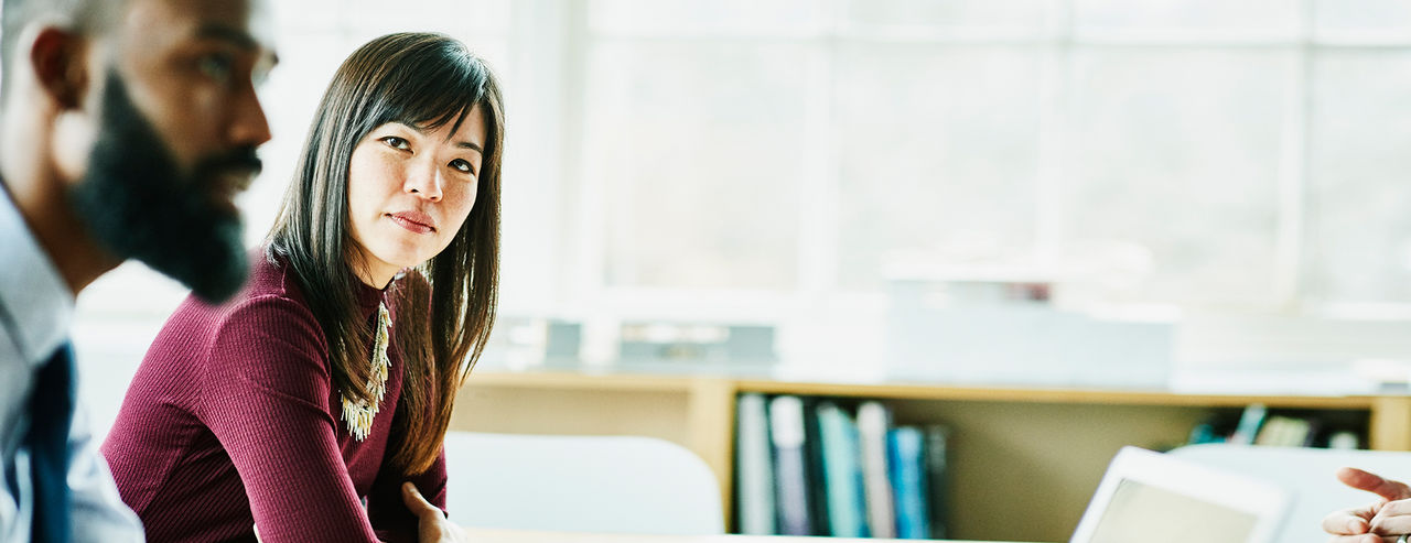 Young woman looking at a man in a sunny room