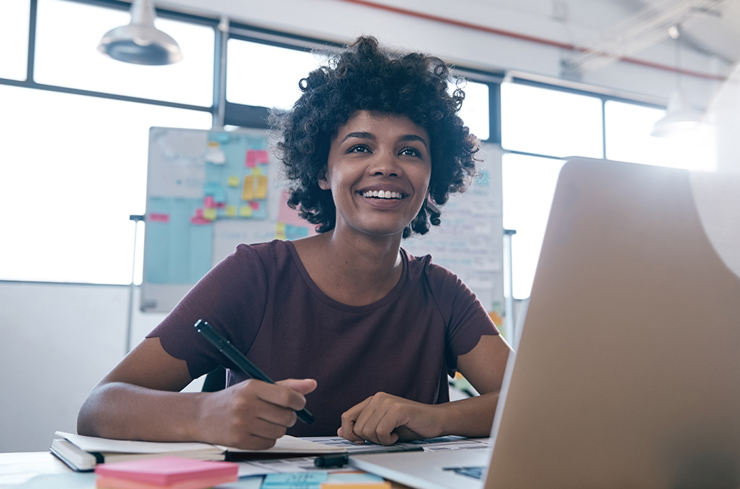 A girl smiling and writing something TFI User Guide article banner